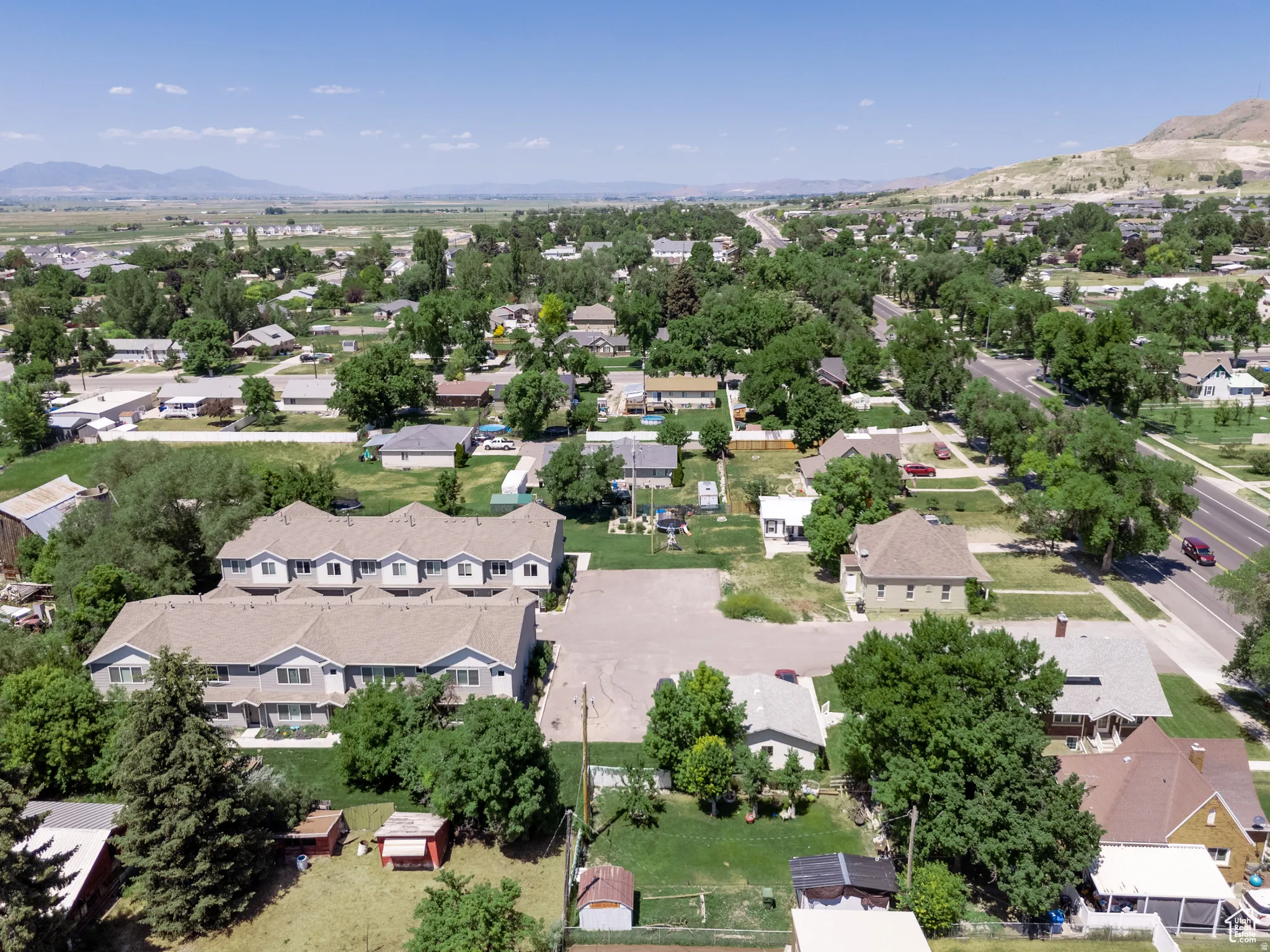 Aerial perspective showcasing a residential area with mature trees and a distant mountain range