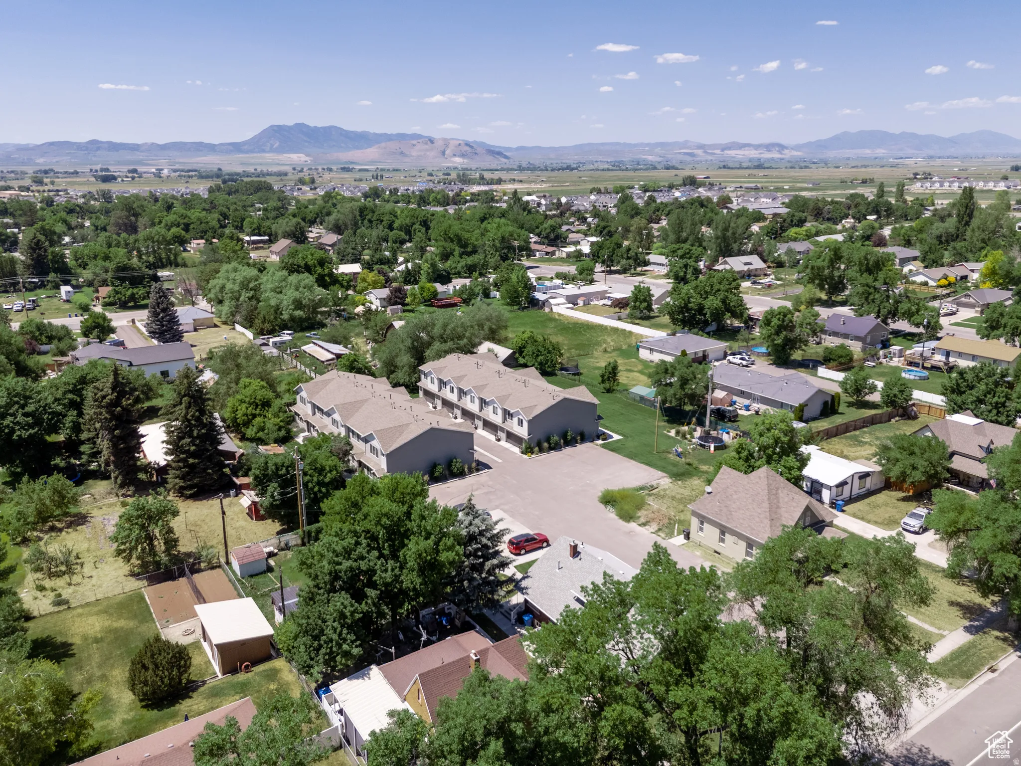 Aerial perspective featuring multiple buildings with tan siding and brown shingle roofs
