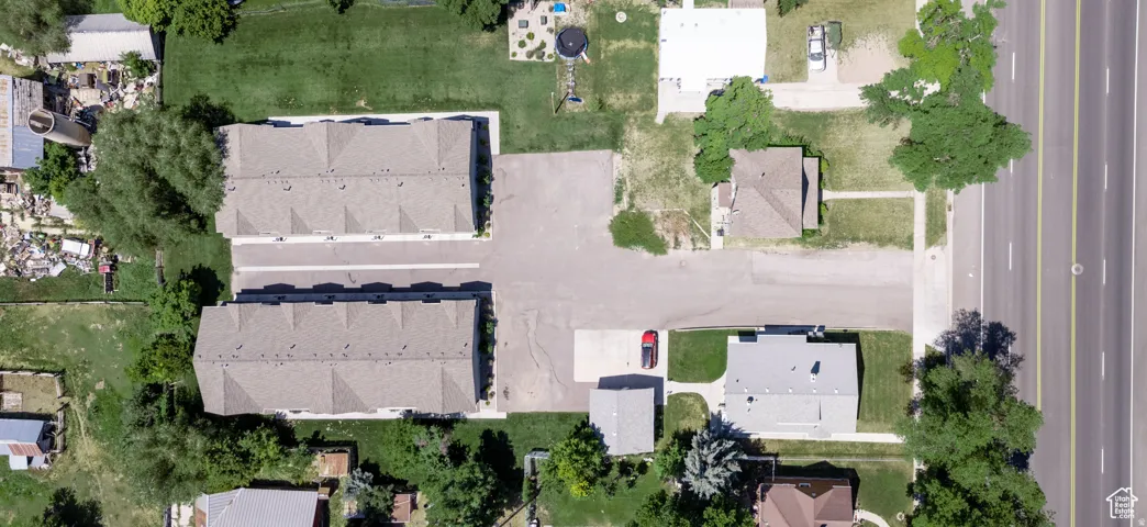 Property featuring two multi-unit buildings with shingle roofs, surrounded by green lawns