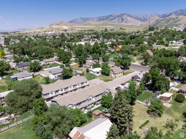 Townhome community situated within a residential area featuring mature trees and a distant mountain backdrop