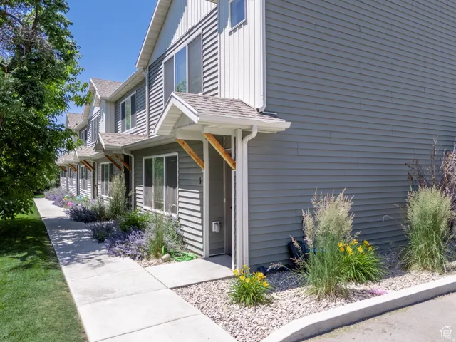 Row of townhomes featuring grey horizontal siding and white vertical siding accents