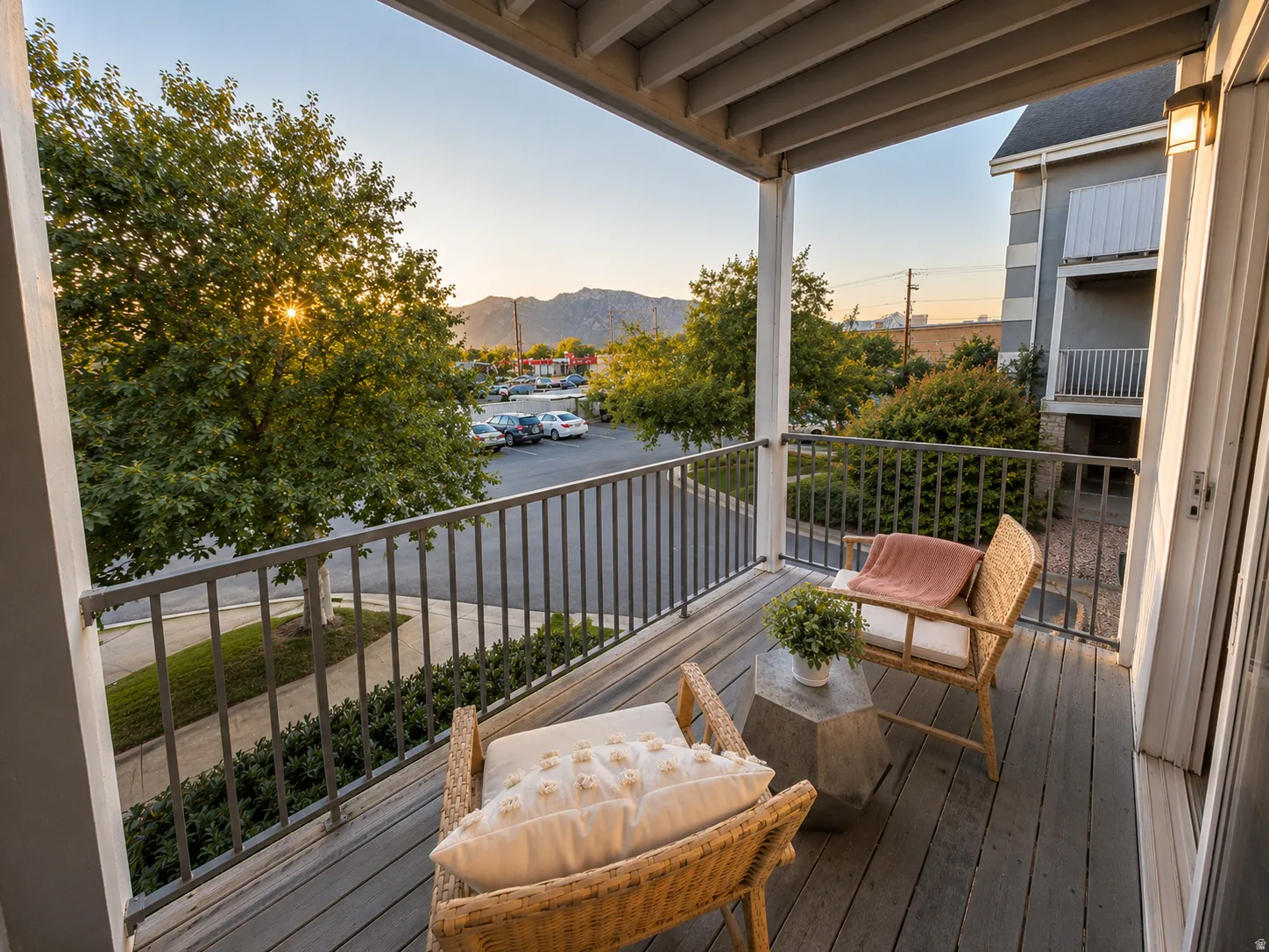 Private balcony featuring durable wood-finish flooring, sturdy metal railings, and an exterior wall lantern