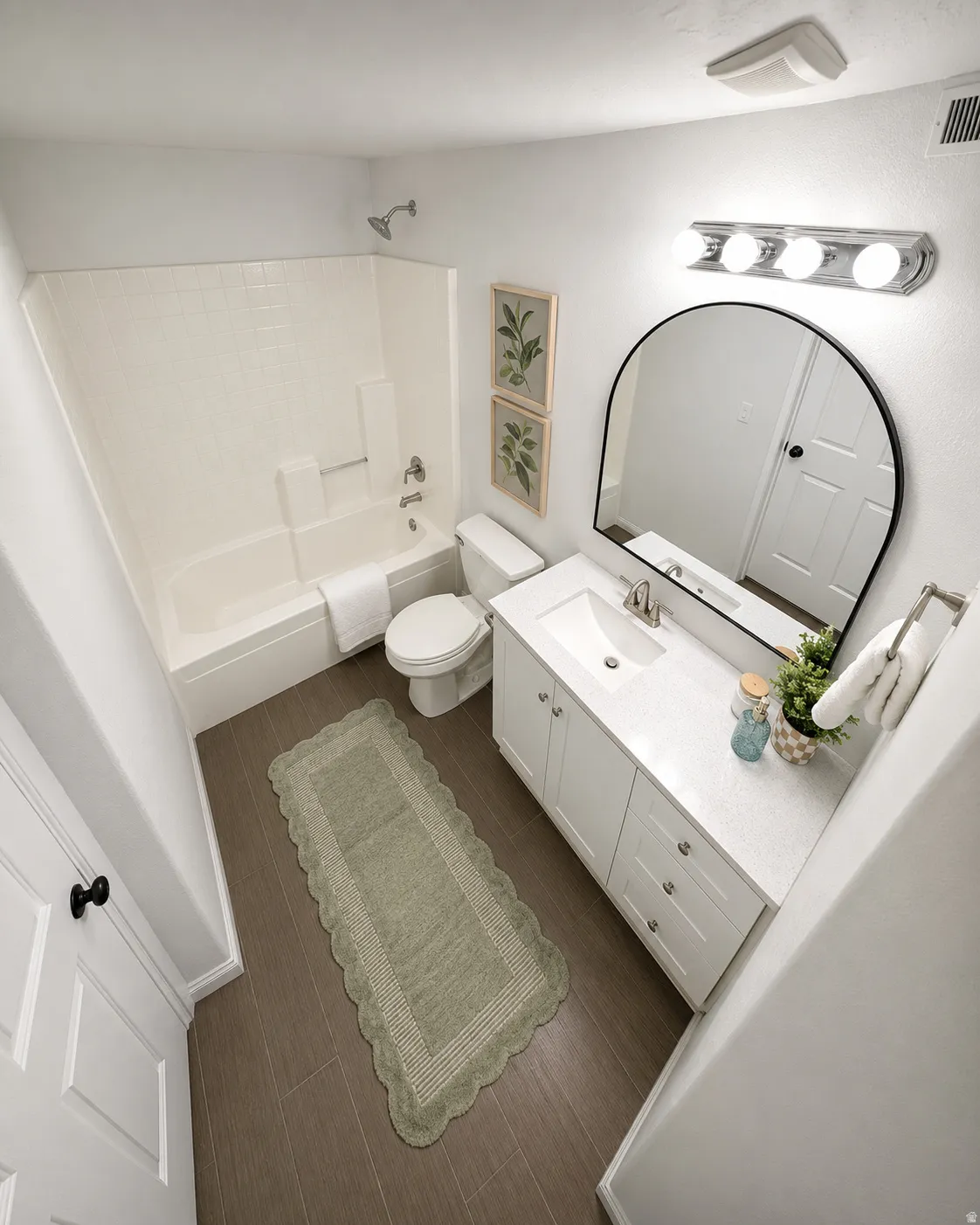Bathroom featuring a white vanity with a quartz-finish countertop, single basin sink, and chrome fixtures