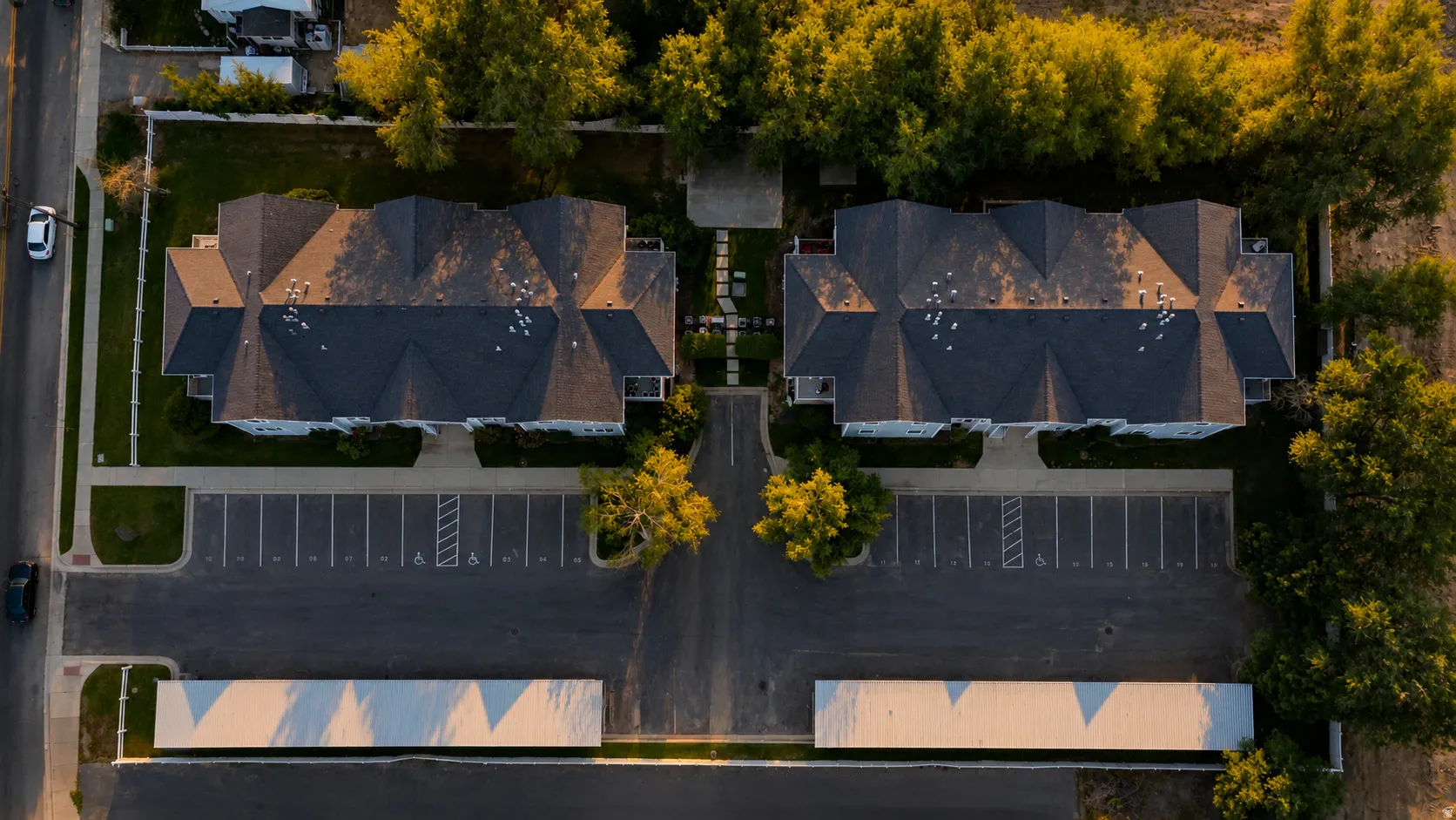 Aerial perspective highlighting two multi-unit structures with dark shingle roofs