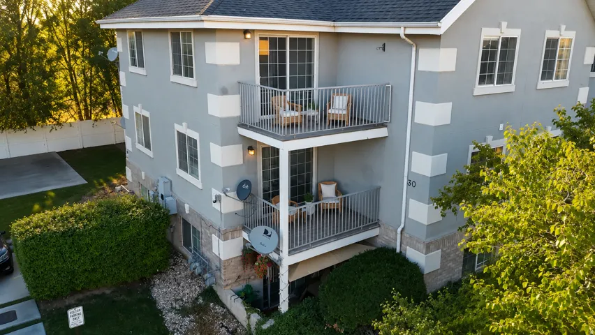 Multi-story building featuring stucco exterior with stone accents and white window trim