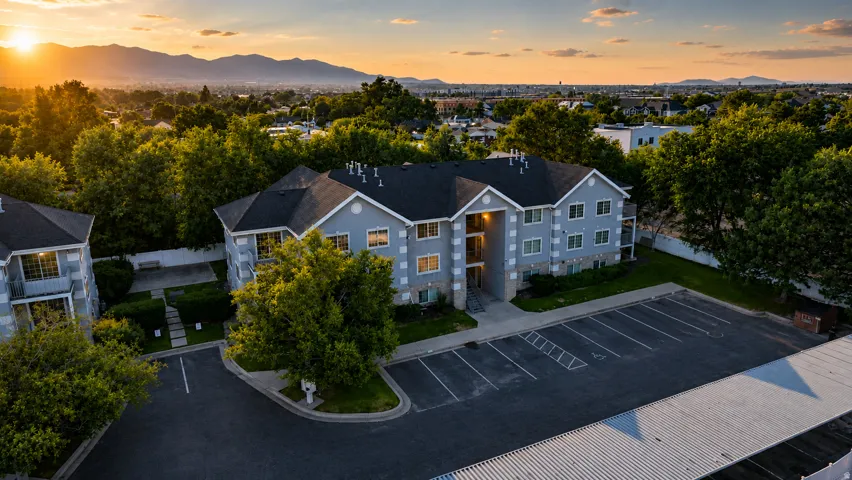 Multi-story residential building with light blue siding and dark shingle roofing