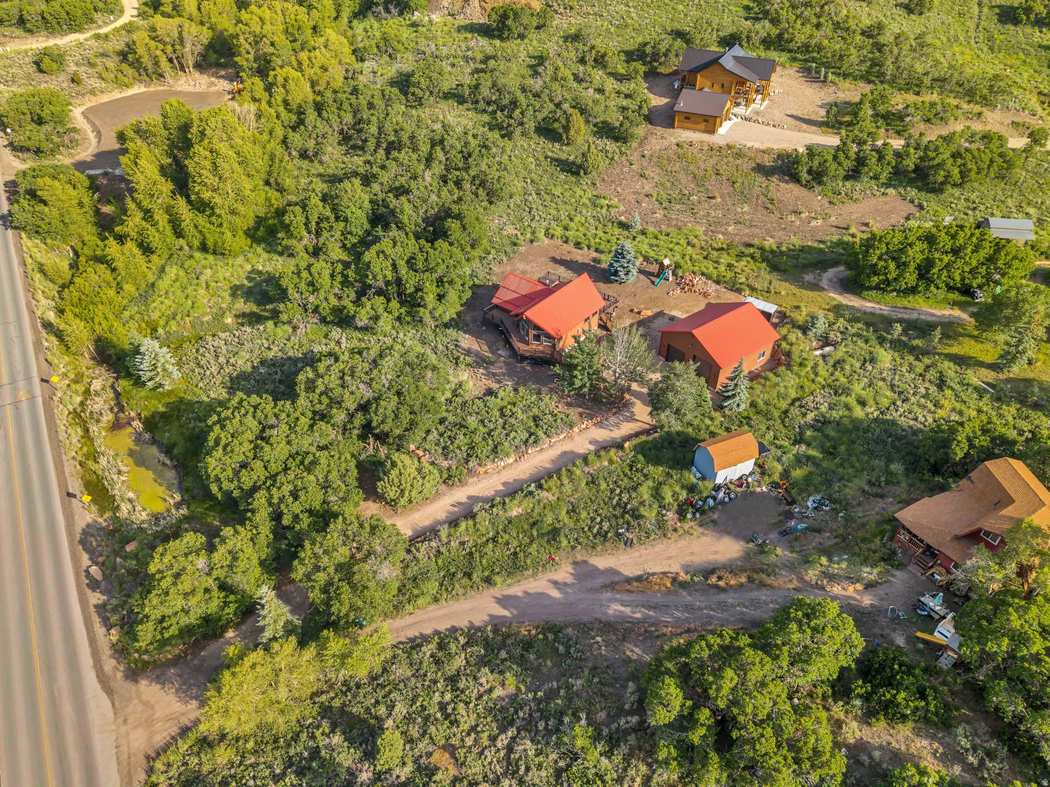 Expansive property featuring several structures, including buildings with red roofs and a multi-level structure with a dark roof