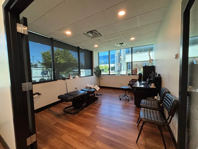 Commercial space featuring wood-finish flooring, drop ceiling with recessed lighting, and expansive windows with roller shades