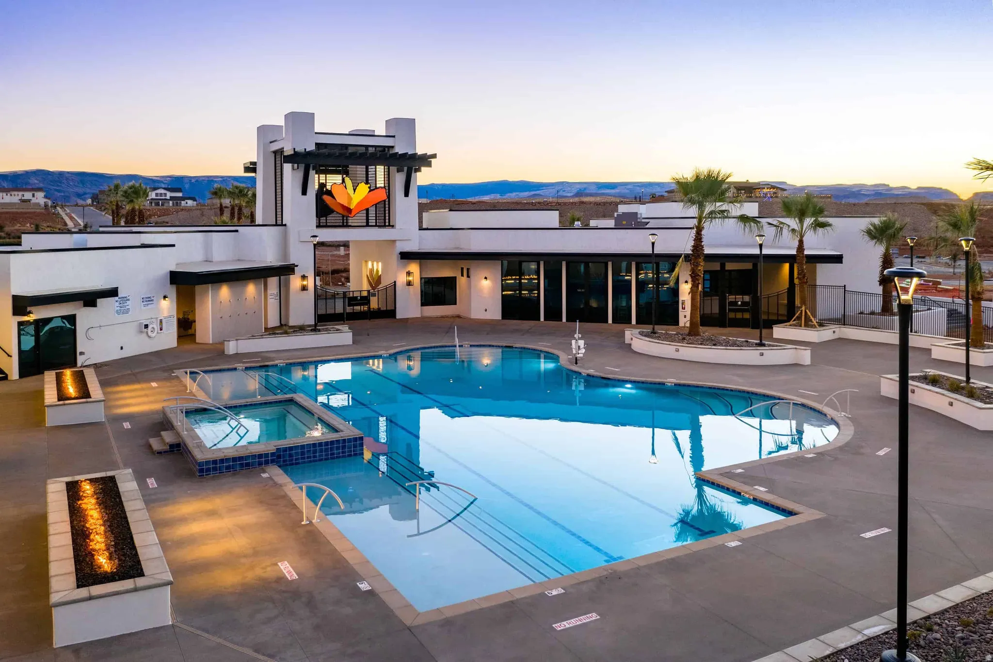 Resort-style pool area featuring a large swimming pool, integrated spa, and fire pits