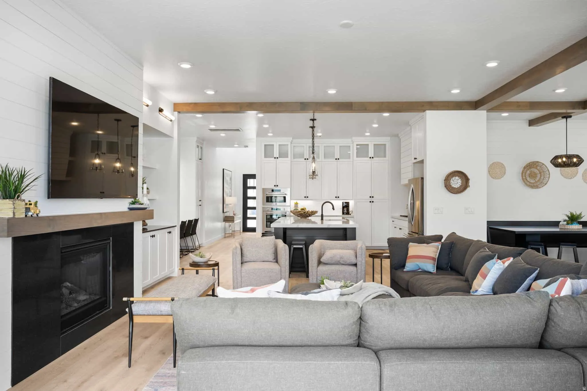 Open-concept living space featuring wood-finish flooring and exposed wood ceiling beams