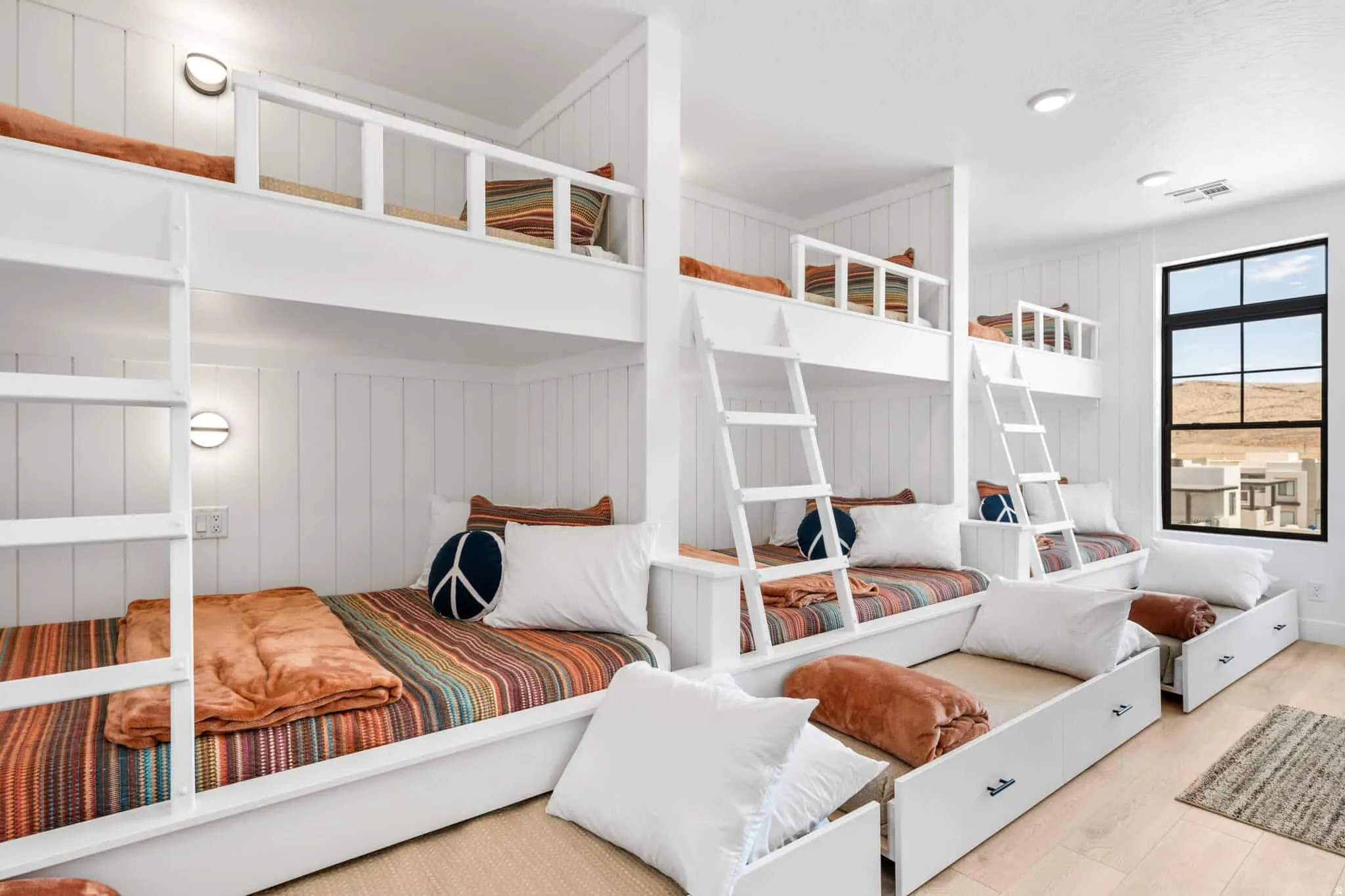 Built-in bunk beds with integrated storage drawers and slatted wall paneling