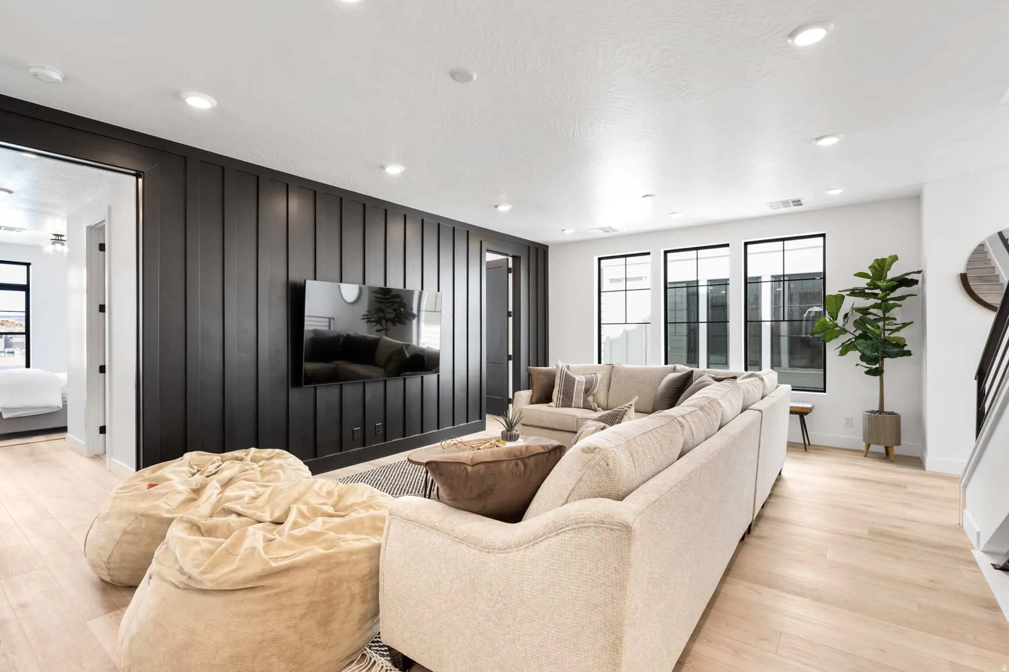 Living space featuring a striking black accent wall with vertical paneling