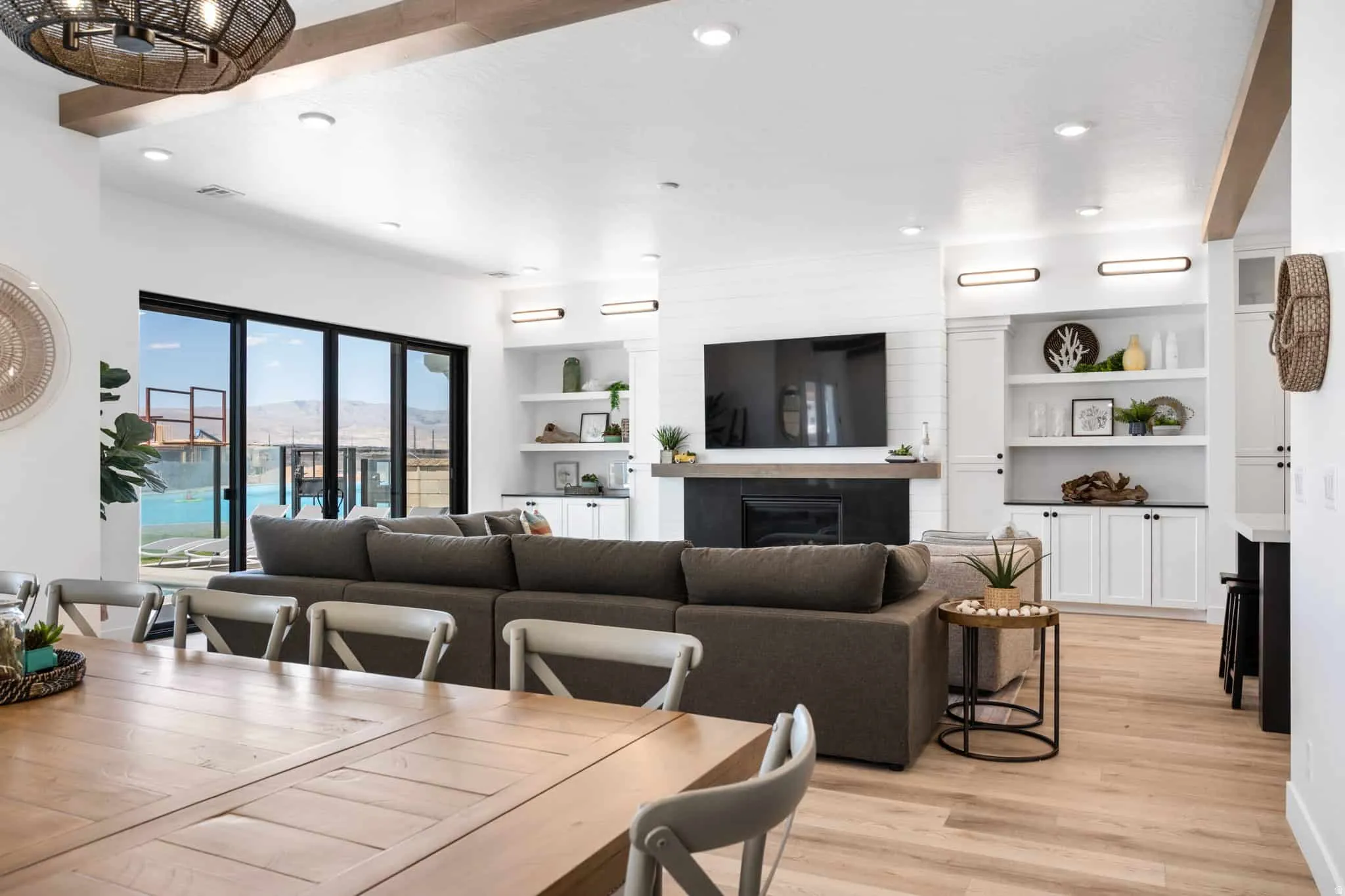 Open-concept living space featuring wood-finish flooring and exposed ceiling beams