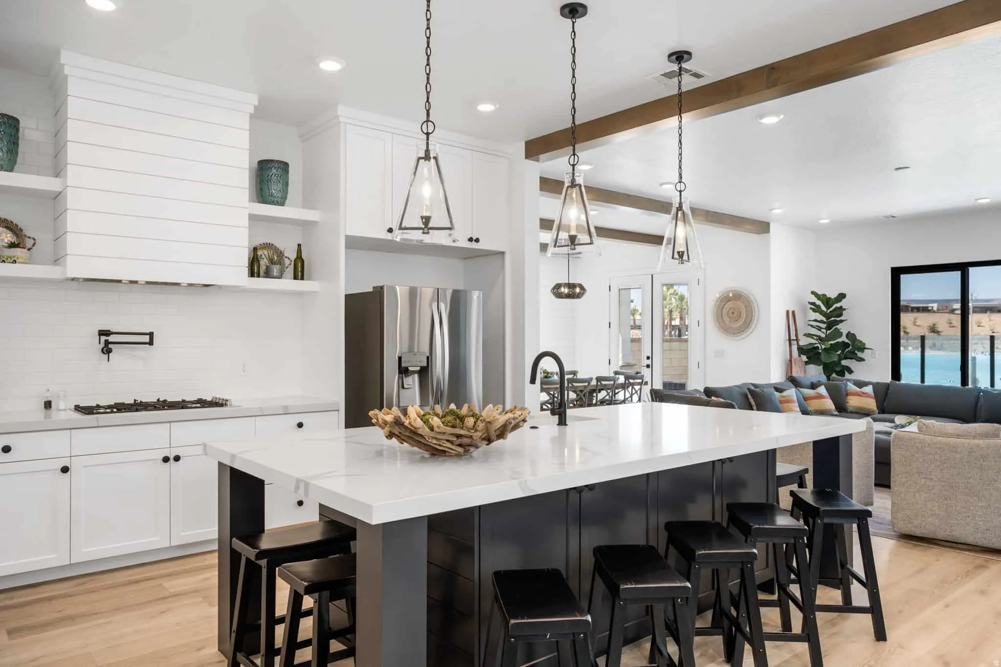 Open-concept kitchen with a large island featuring a white countertop and seating for four