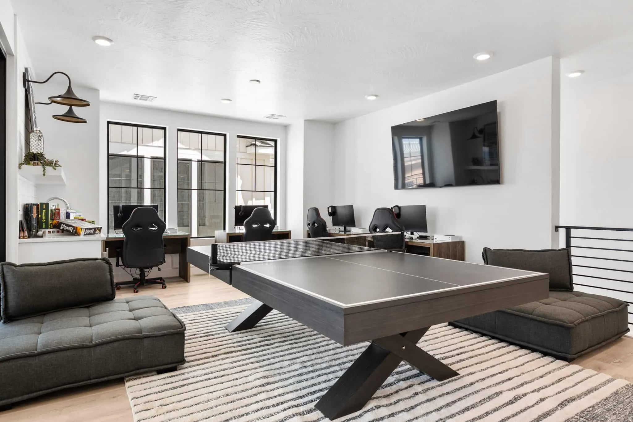 Spacious loft area featuring recessed lighting, light wood-finish flooring, and a contemporary railing system
