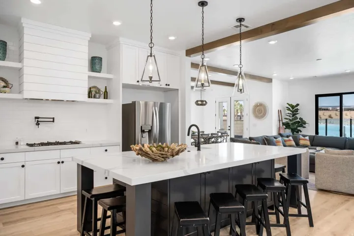 Open-concept kitchen with a large island featuring a white countertop and seating for four