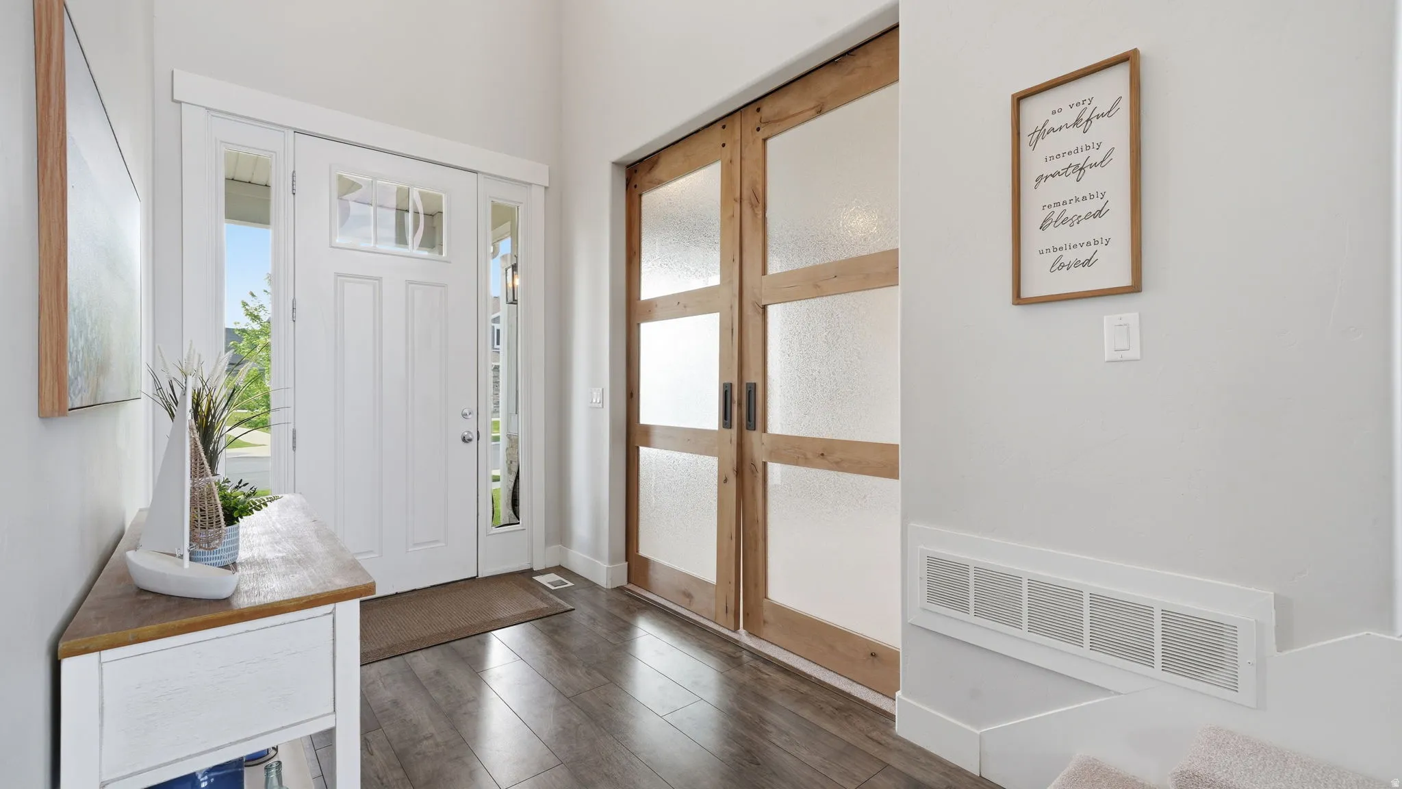 Entryway featuring a white paneled front door with sidelights and an upper transom window