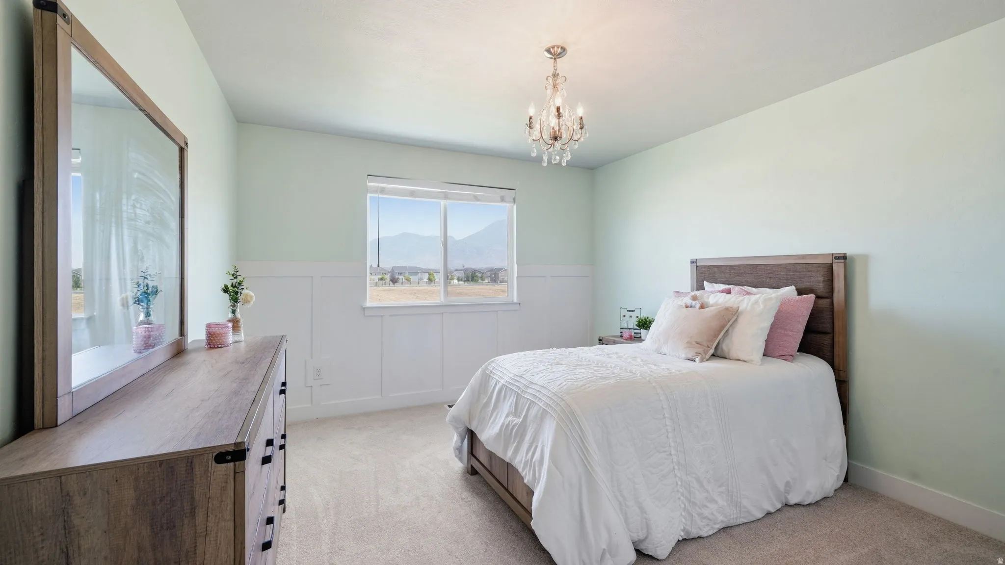 Light-filled room featuring a chandelier light fixture, wood-finish flooring, and a large window