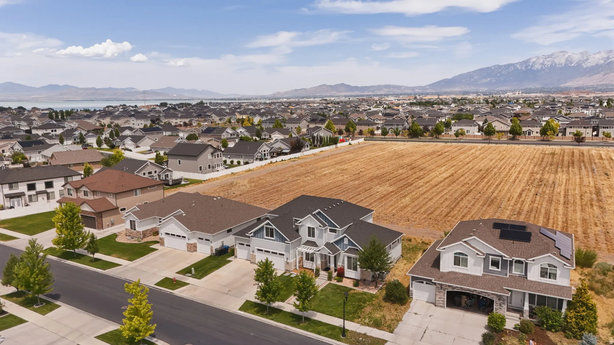 Aerial perspective showcasing a residential community with distant mountains and a body of water