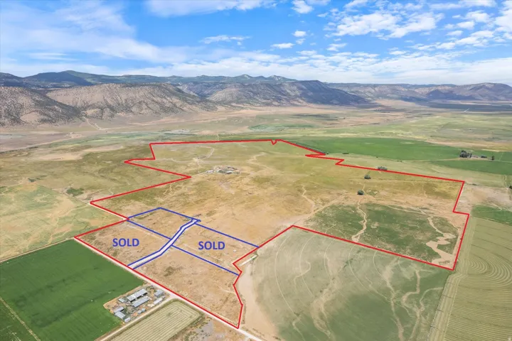Expansive undeveloped land featuring diverse terrain, distant mountains, and agricultural fields