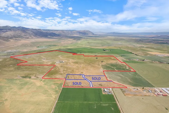 Expansive undeveloped acreage with diverse terrain, bordered by agricultural fields