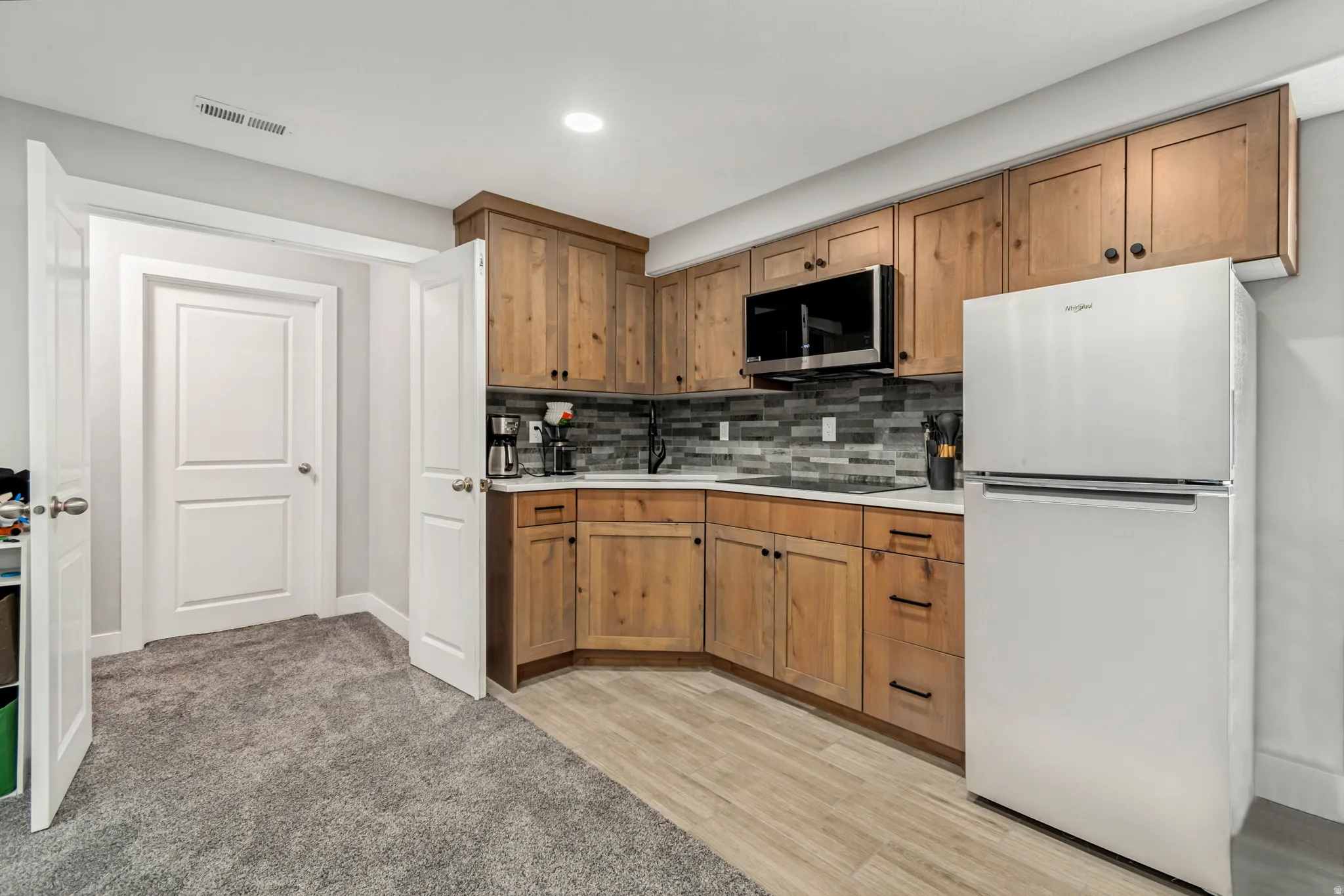 Corner kitchen with wood cabinetry and dark hardware