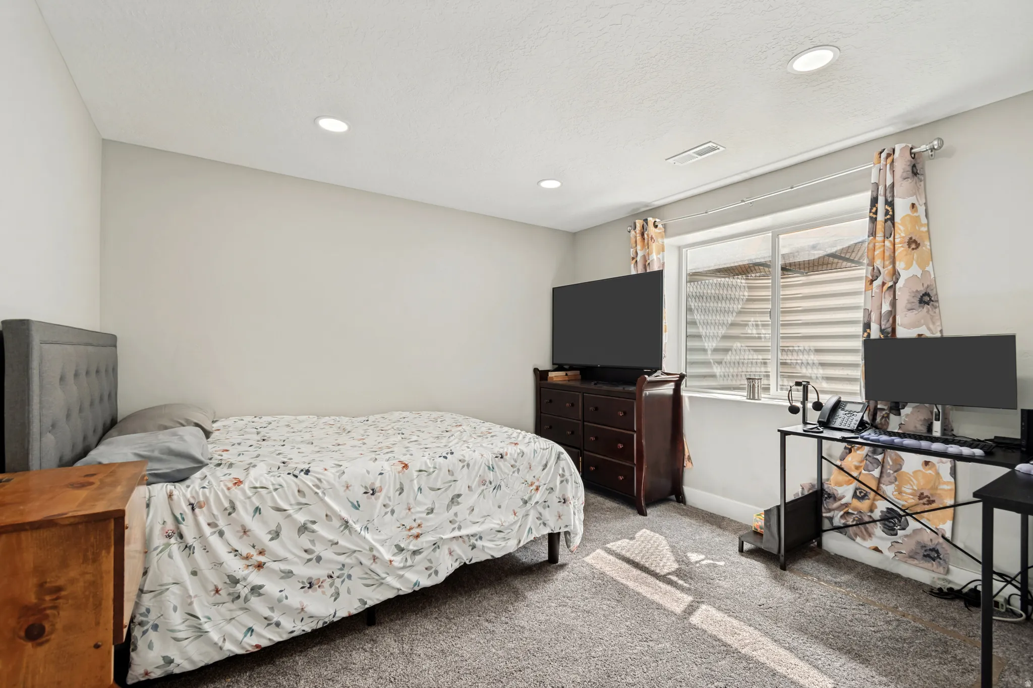 Carpeted room featuring light gray walls, recessed lighting, and a large window