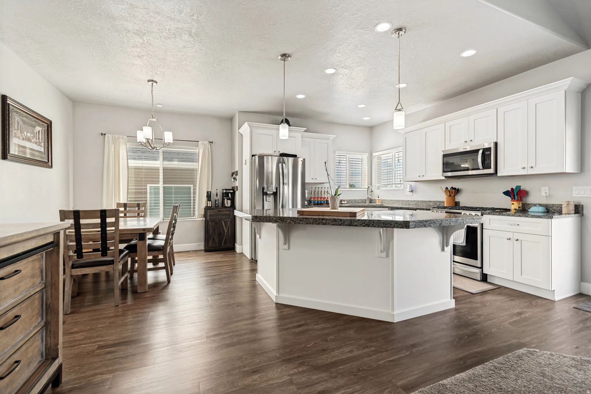 Open-concept kitchen and dining area featuring wood-finish flooring