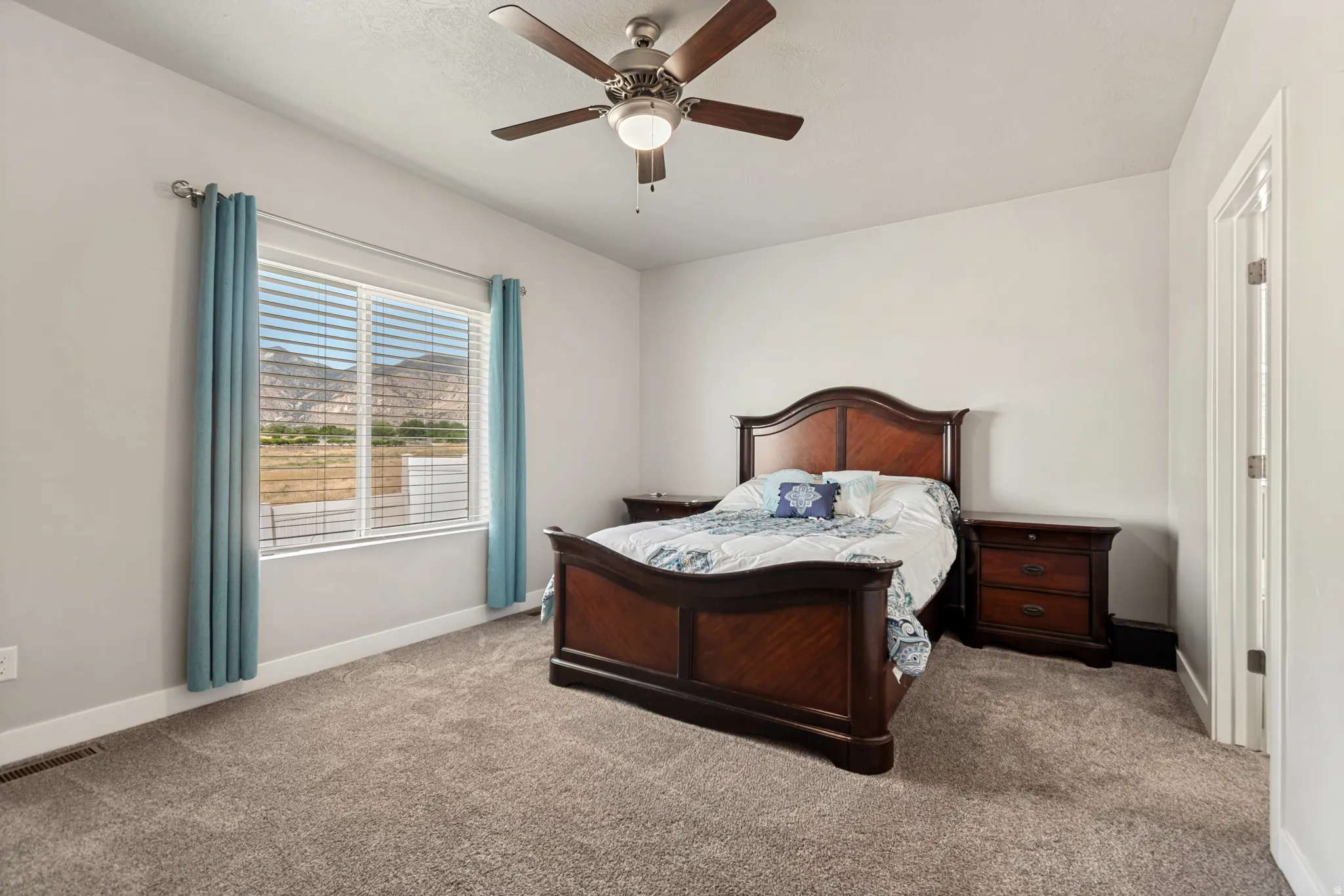 Carpeted room featuring a ceiling fan with integrated lighting, a window with horizontal blinds, and white baseboards