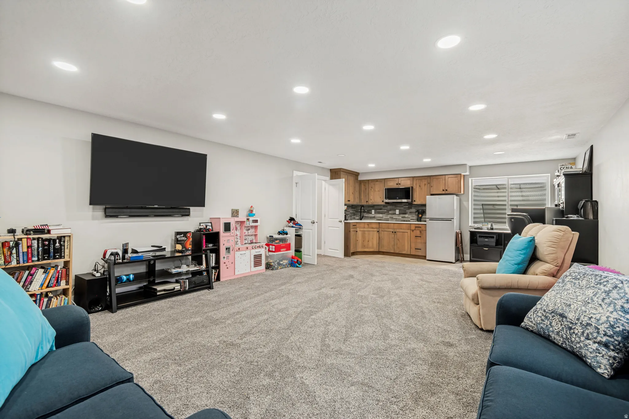 Spacious lower-level area featuring recessed lighting and gray carpeting