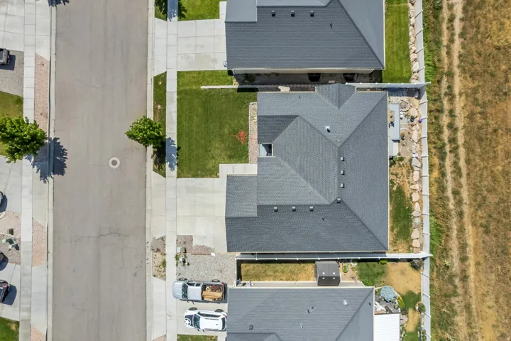 Aerial perspective featuring a property with a multi-gabled roofline and an adjacent manicured lawn