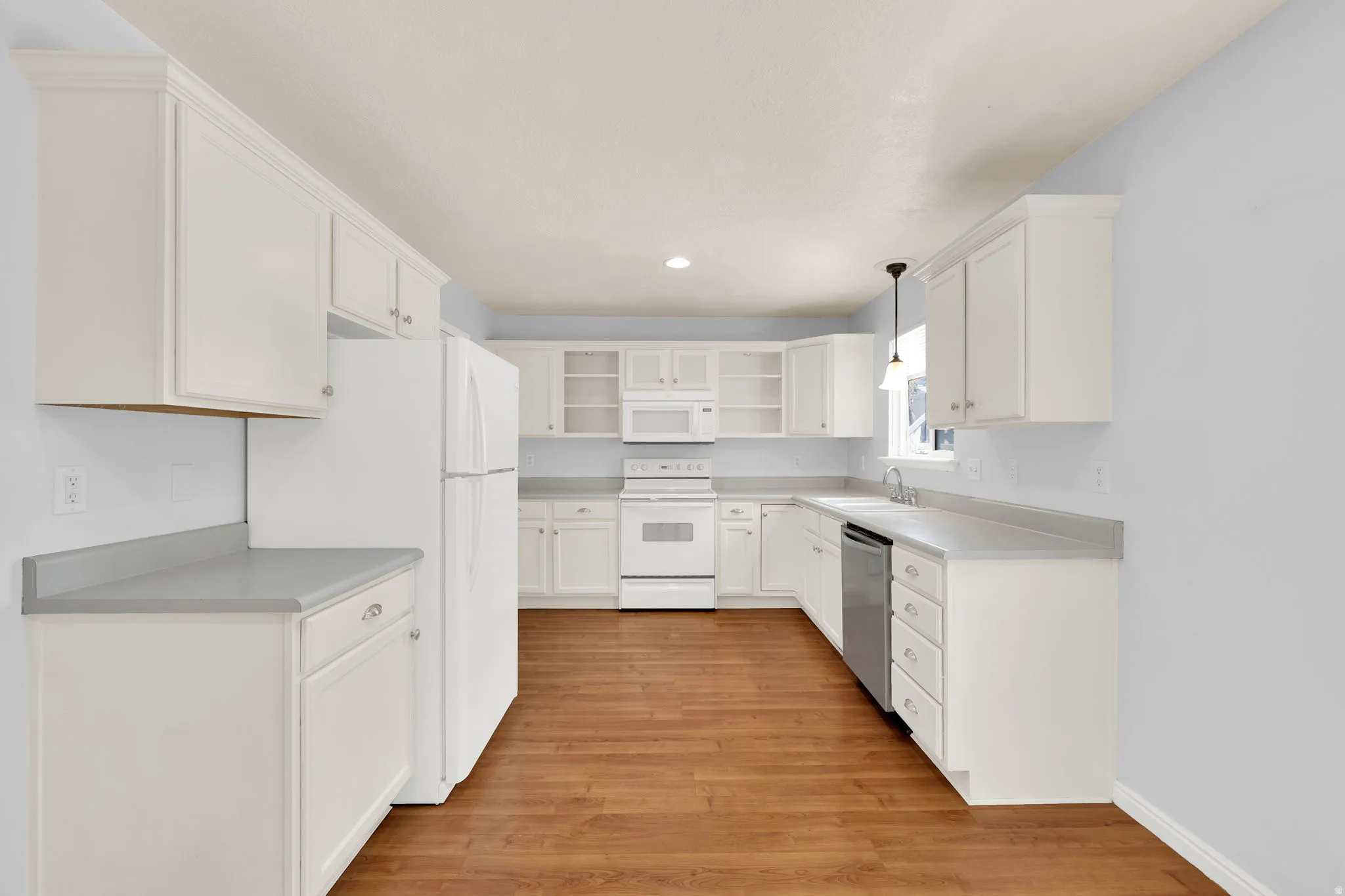 Kitchen featuring white cabinetry, light gray countertops, and wood-finish flooring