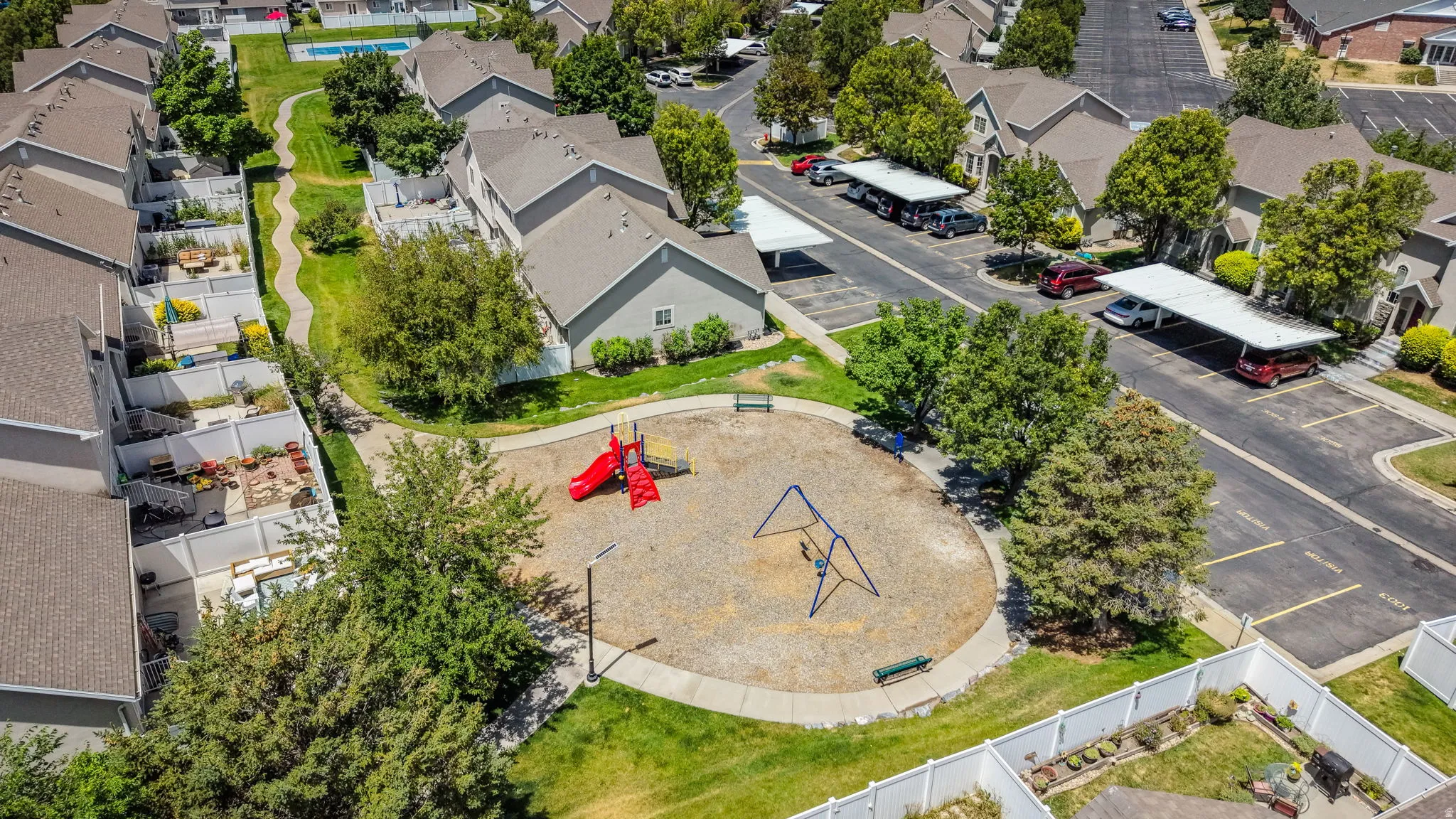 Central community playground featuring a red slide and blue swing set