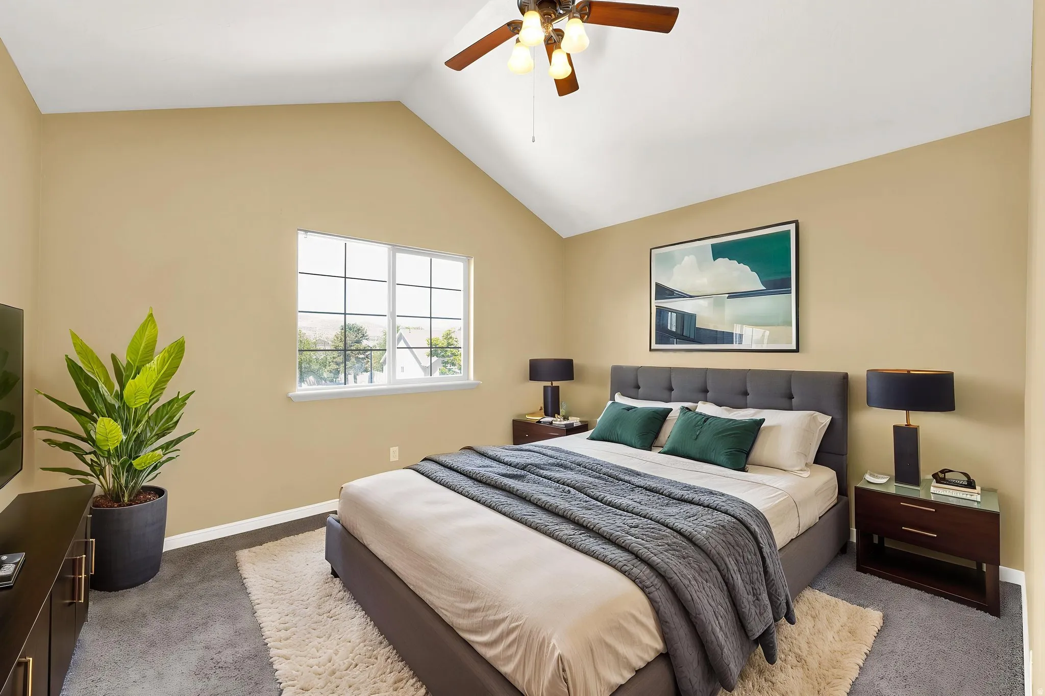 Vaulted ceiling bedroom with a ceiling fan, a multi-paned window, and carpet flooring
