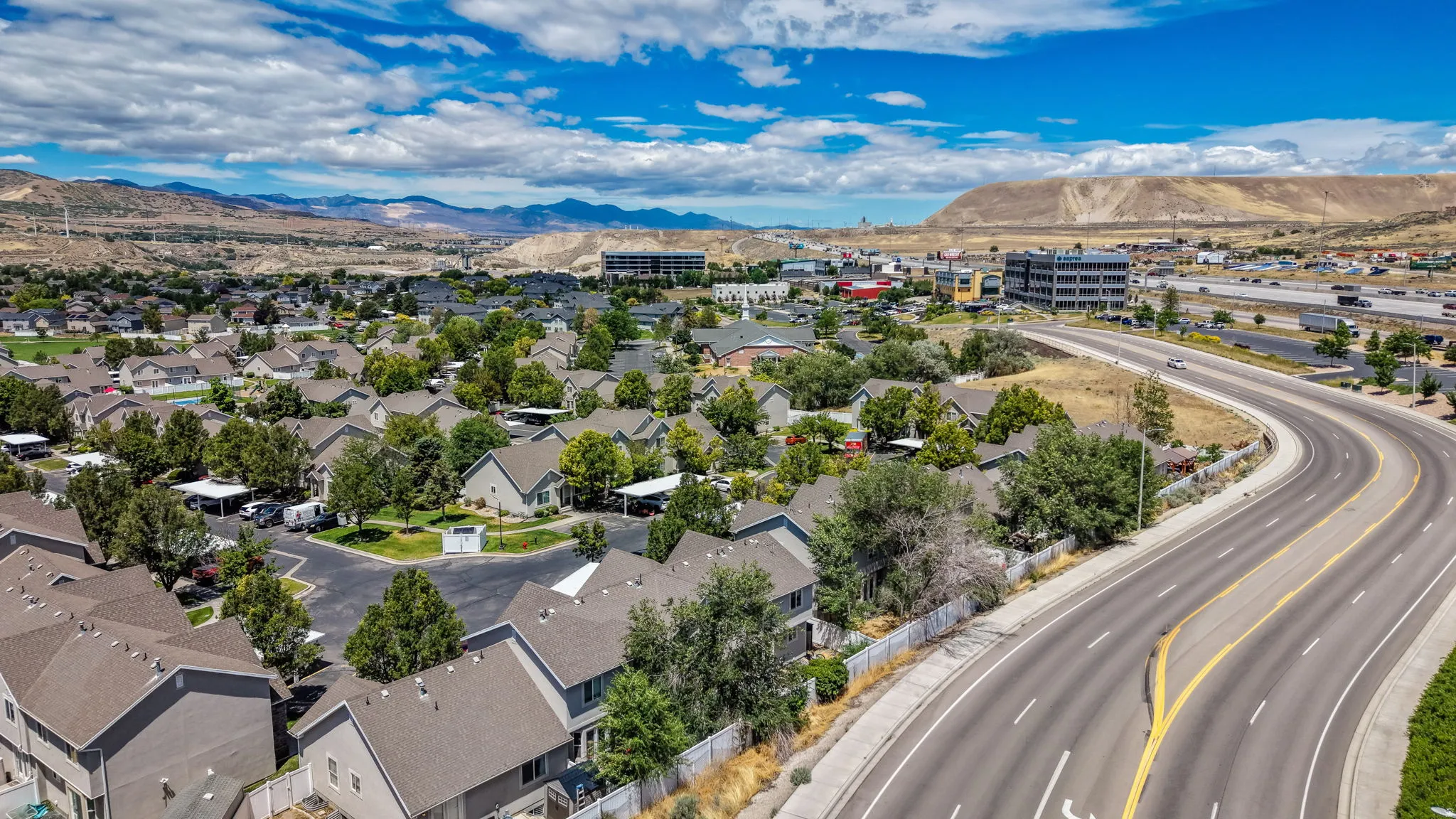 Aerial perspective showcasing a residential community with numerous single-family homes and mature trees