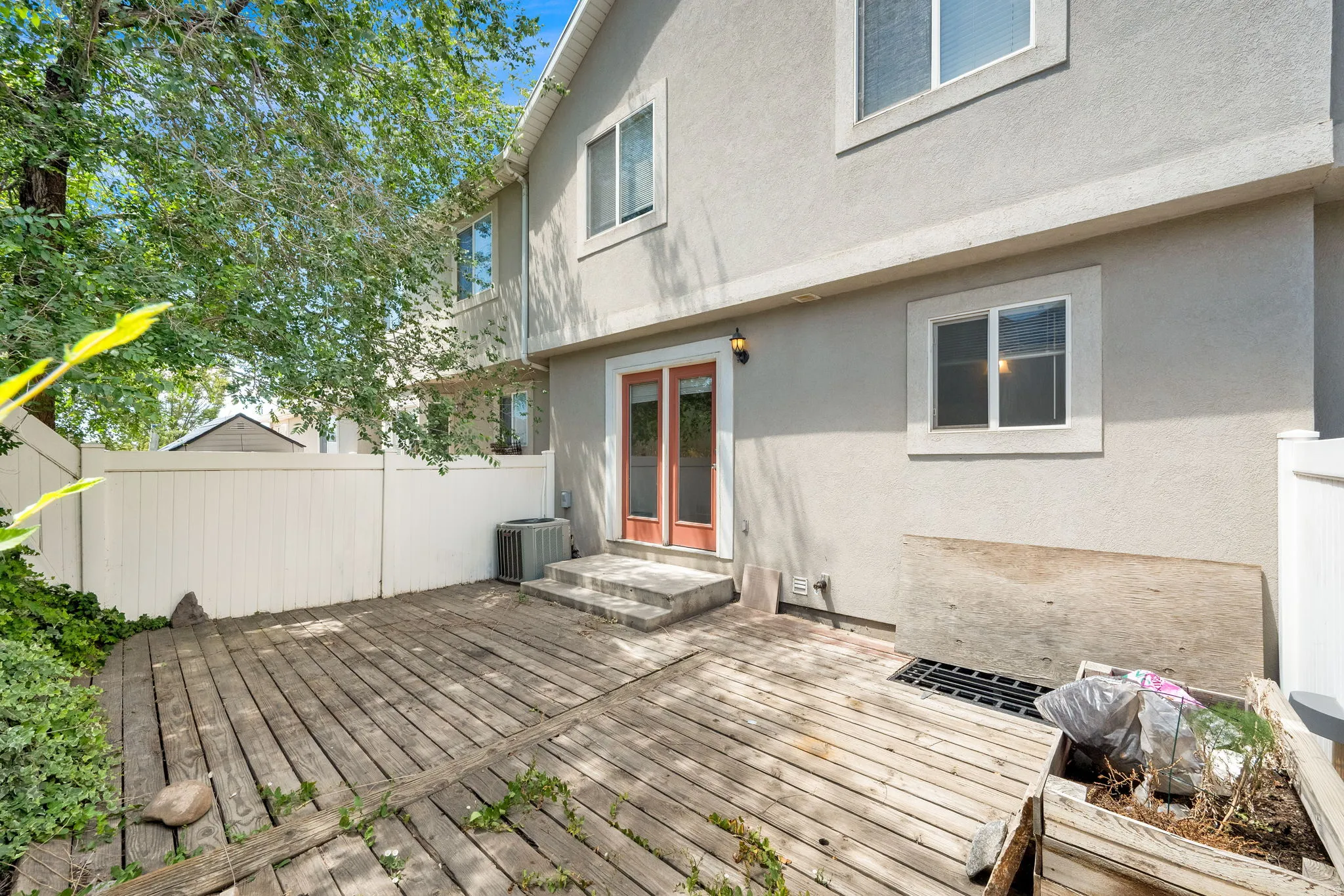Ground-level wood deck area with privacy fencing