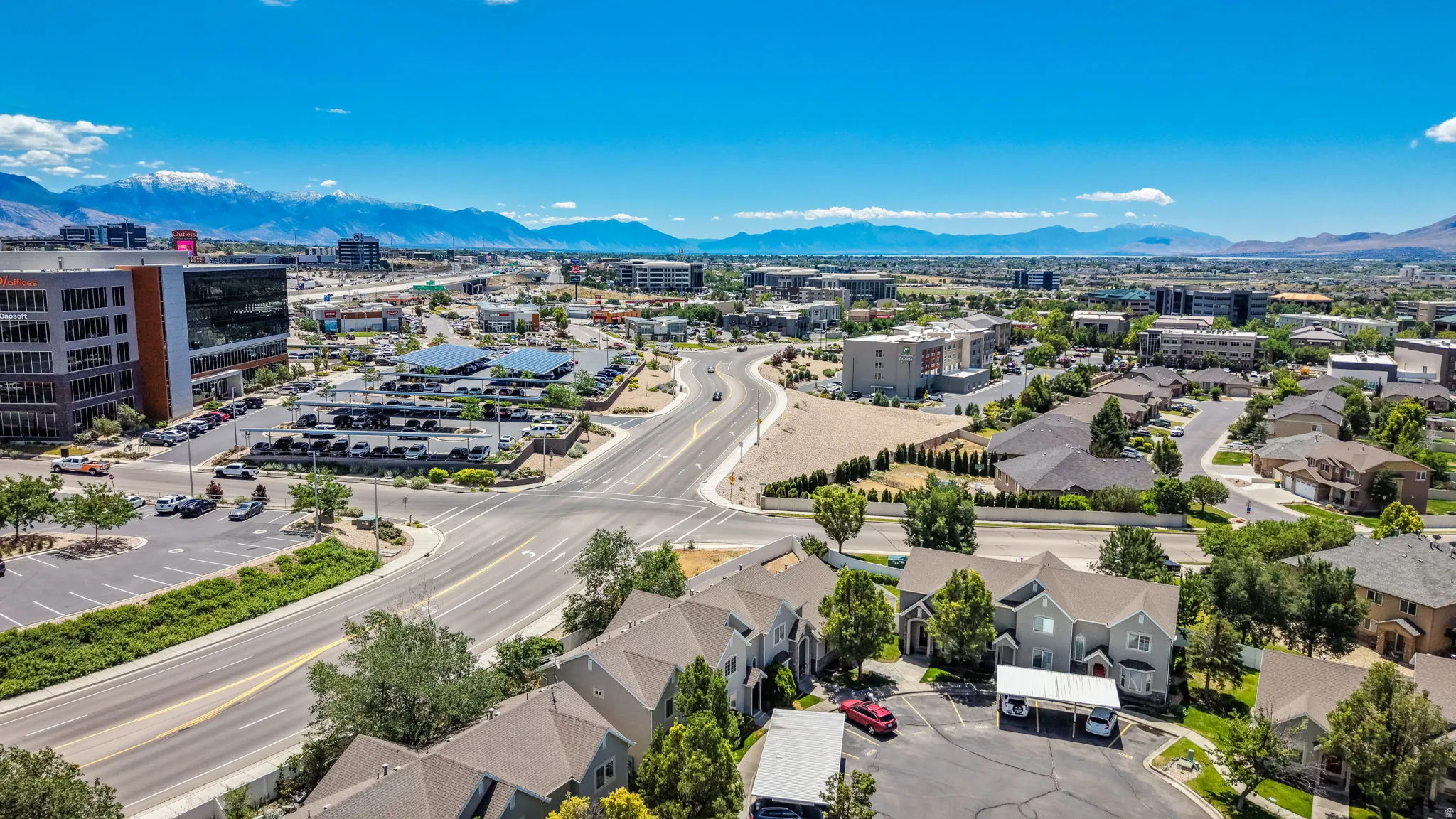 Expansive aerial perspective showcasing a developed urban area with commercial buildings, residential structures, and established roadways