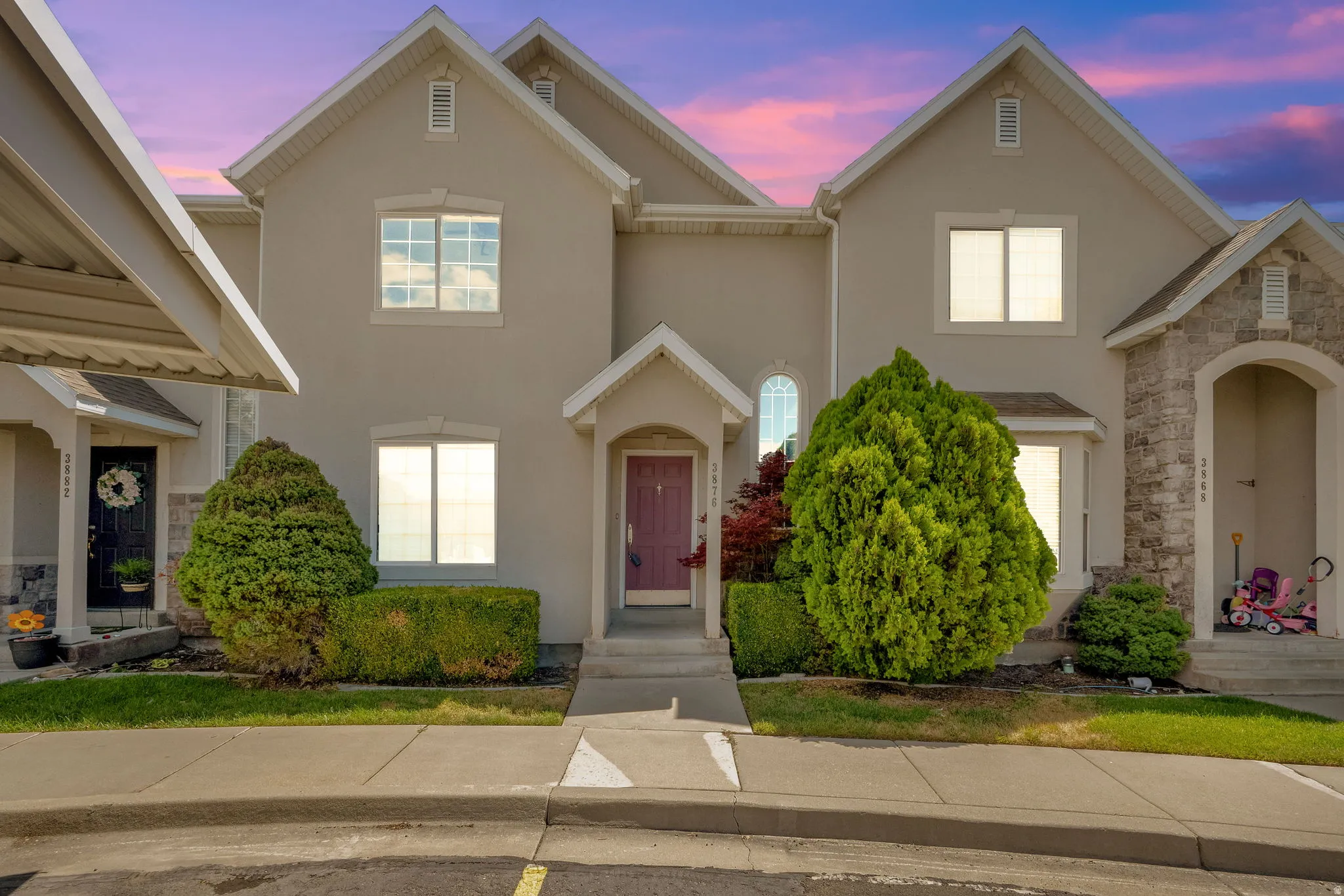 Multi-level stucco exterior with gabled rooflines, arched entry, and stone accents