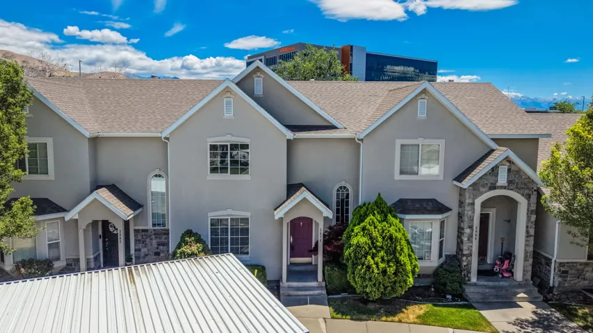 Contemporary multi-story exterior featuring stucco siding and stone accents