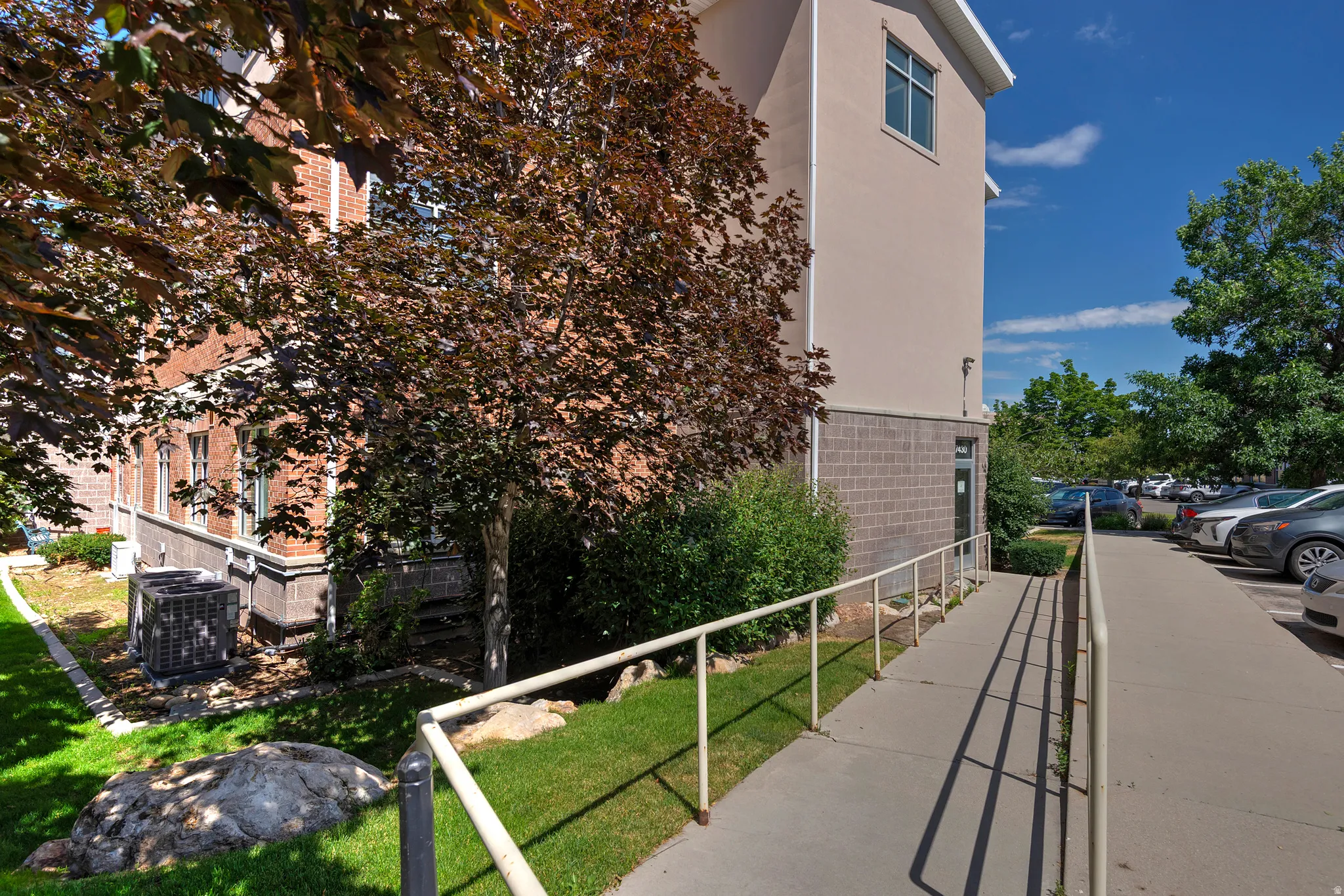 Exterior building with a red brick facade and light-colored stucco sections