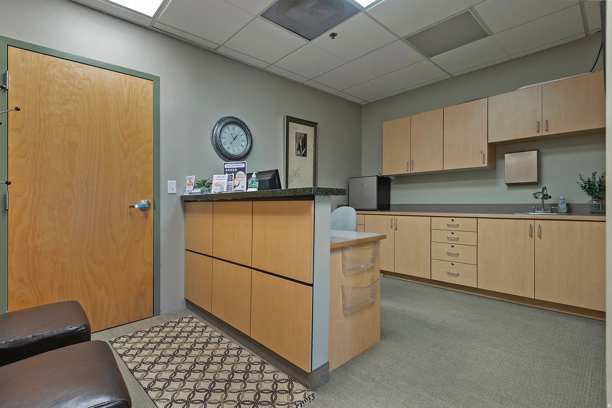 Built-in reception desk with a dark countertop and light wood-finish cabinetry