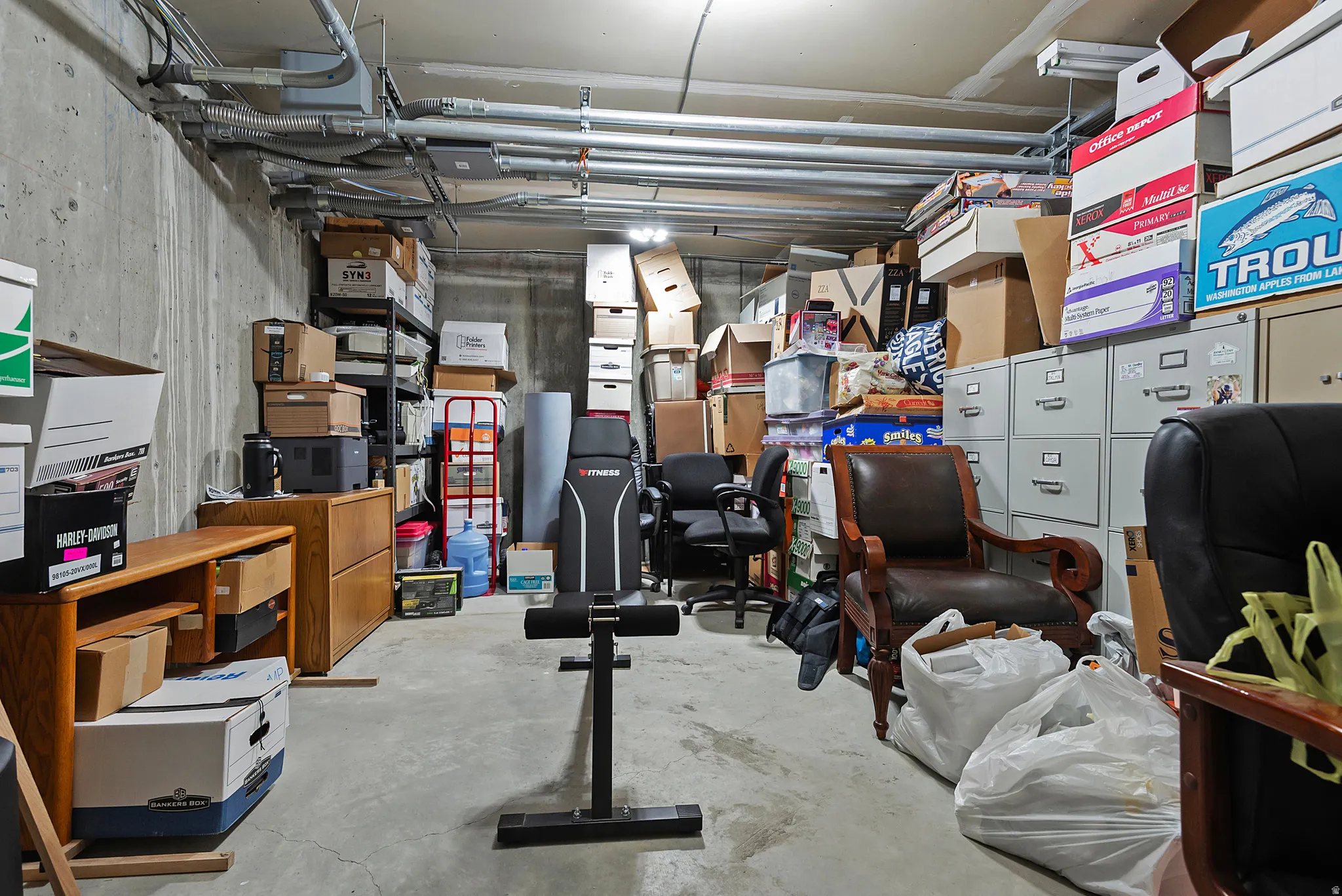 Unfinished basement space with exposed concrete walls and ceiling
