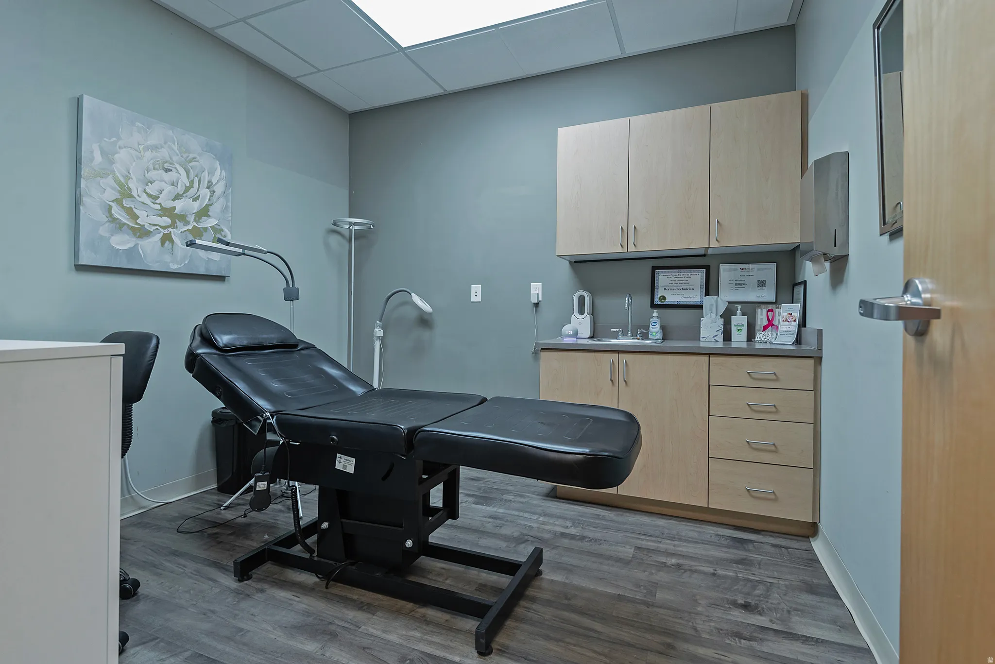Vinyl plank flooring and recessed lighting illuminate this versatile space featuring neutral wall paint