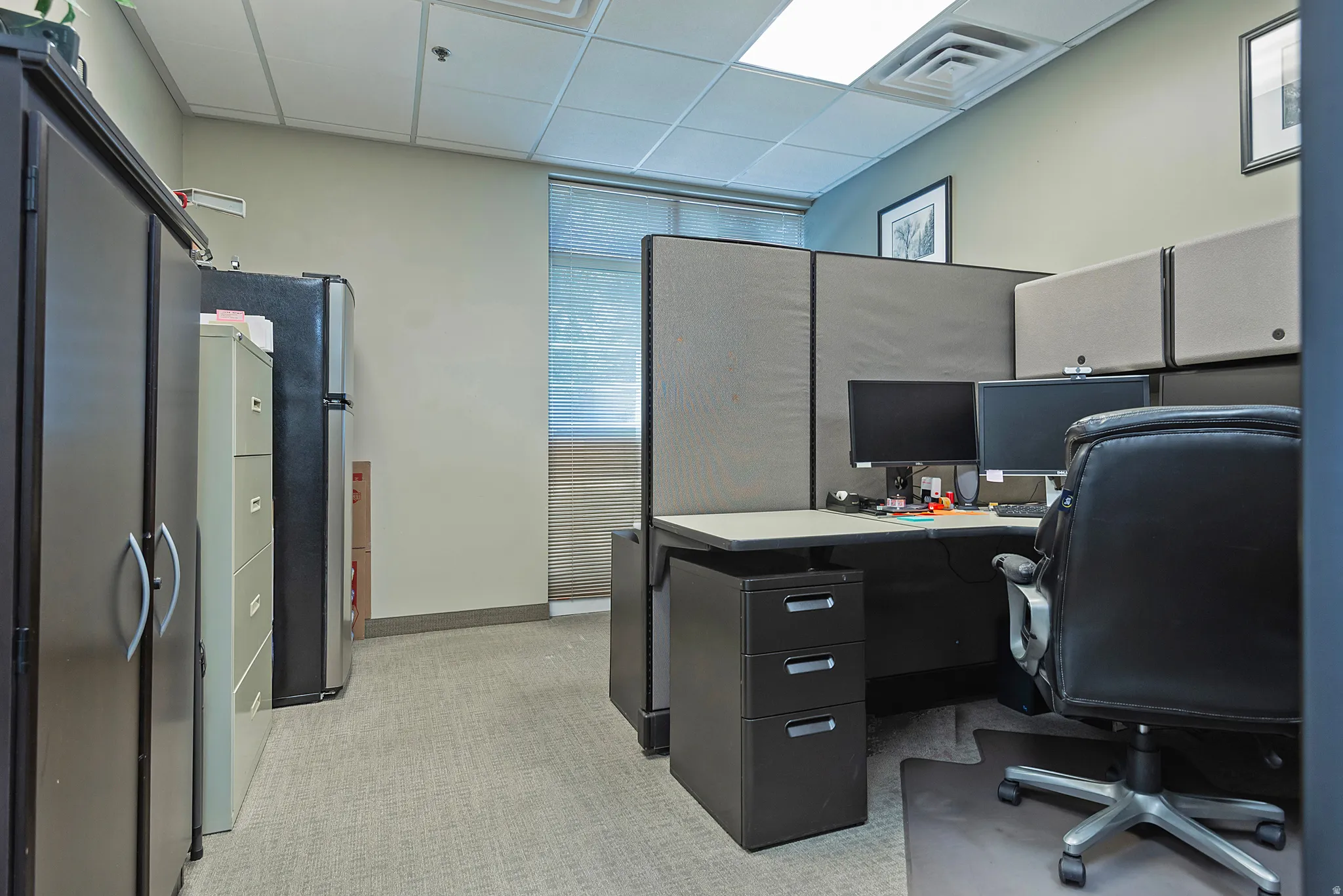 Dedicated workspace featuring neutral wall tones, recessed lighting, and carpeted flooring