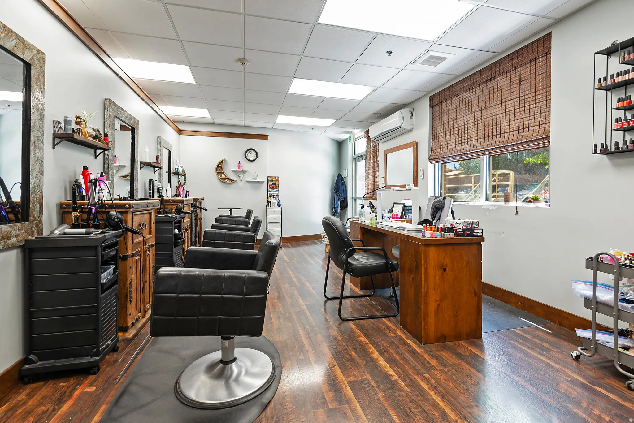 Commercial interior featuring wood-finish flooring, recessed ceiling lighting, and a large window with a woven shade