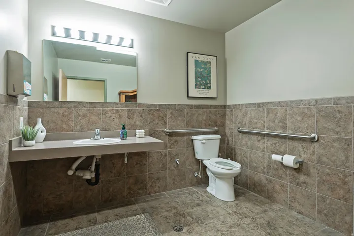 Bathroom featuring a floating sink with a single-handle faucet, full vanity mirror, and linear light fixture