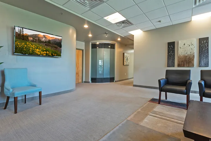 Spacious interior with neutral carpeting and a dropped ceiling with recessed lighting
