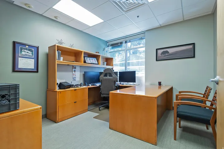 Dedicated office space featuring expansive built-in wood-finish cabinetry and shelving