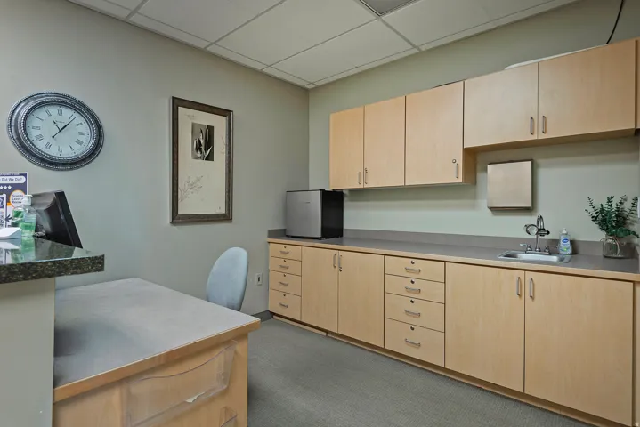 Functional workspace featuring extensive light wood-finish cabinetry, a built-in sink, and integrated counter space