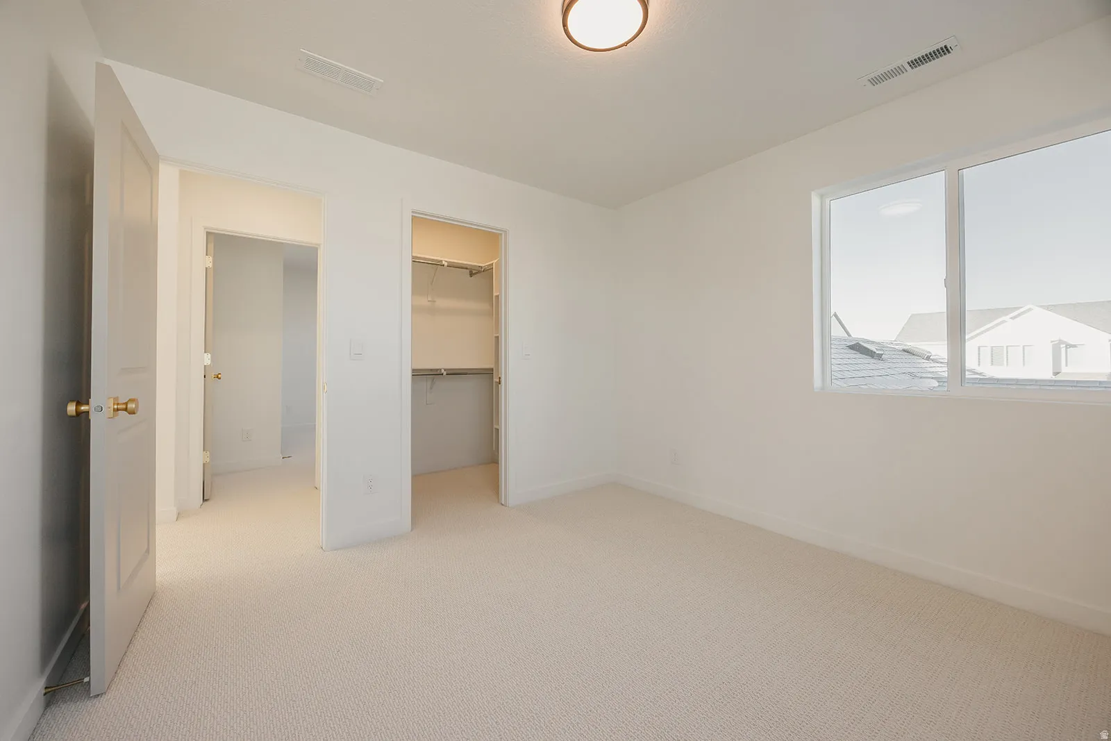 Carpeted room with a double-pane window providing natural light